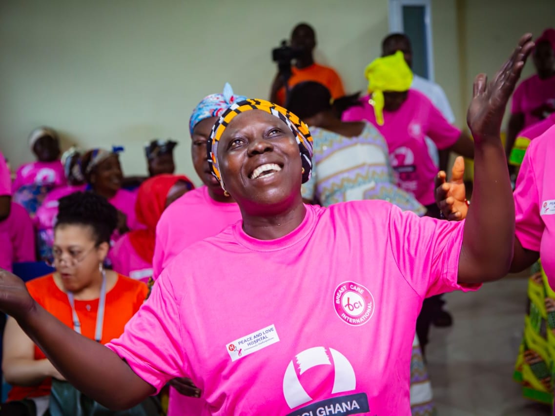 A woman celebrating at a BCI breast-cancer outreach in Ghana